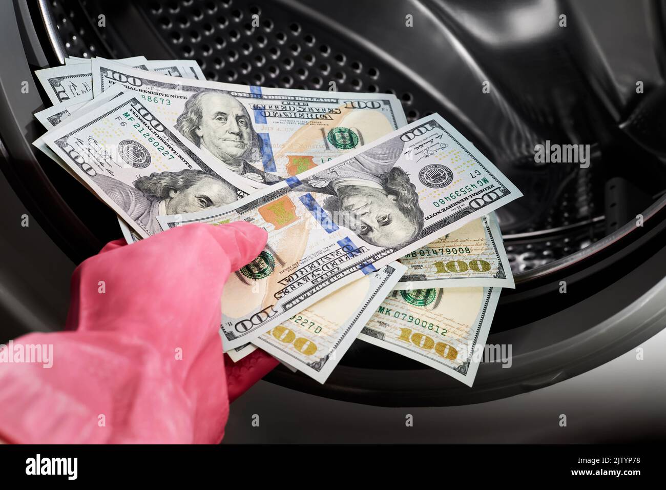 Closeup of a person hand in a rubber glove putting dollars in washing