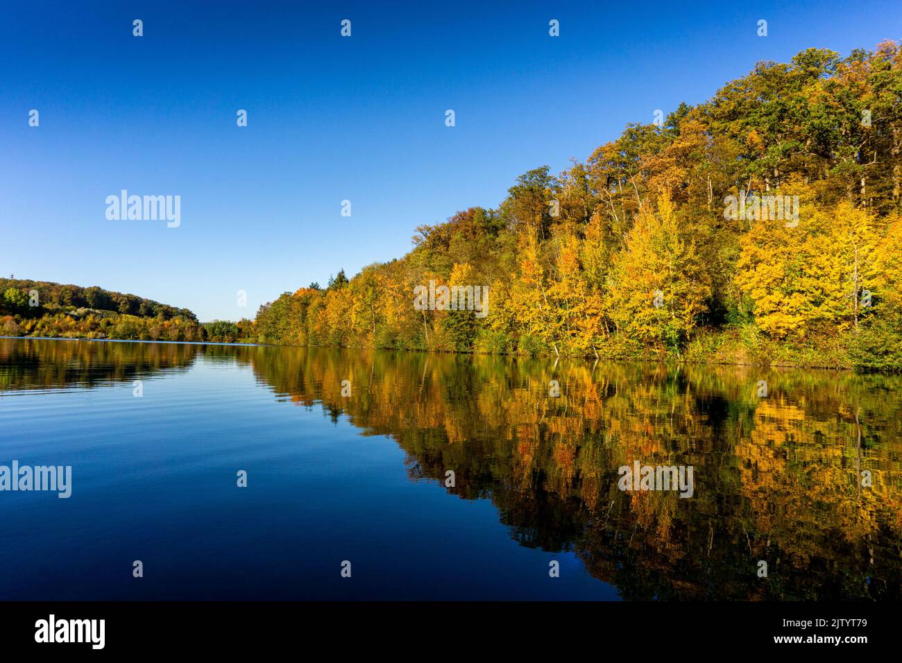 A beautiful scene of colorful trees reflecting on Michelbach See in Zaberfeld, Germany Stock Photo