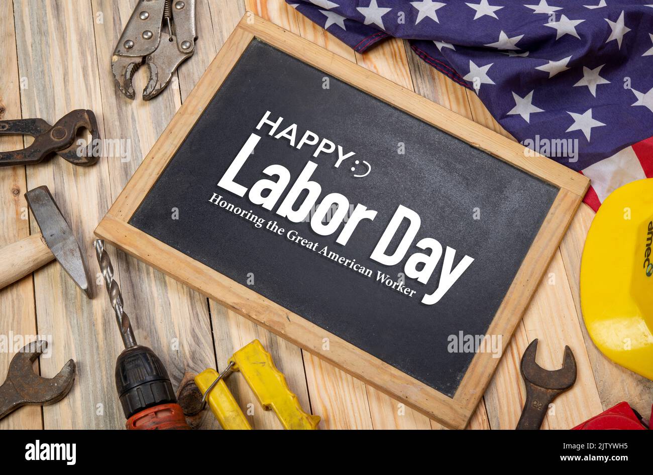 Honoring American Labor with USA flag and hardware tools around the blackboard banner. Stock Photo