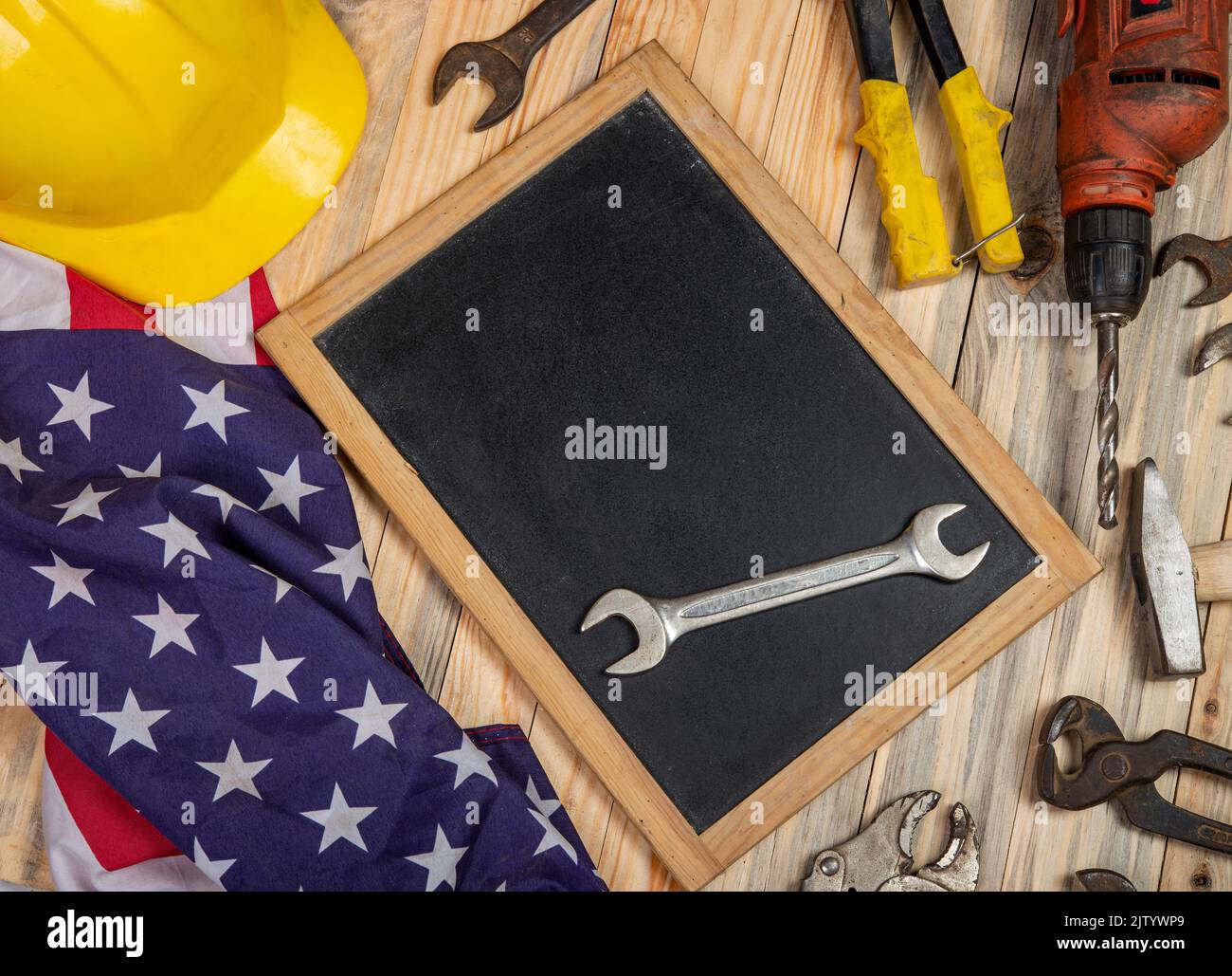 Screwdriver on blackboard with copy space and USA flag - labor day conceptual banner. Stock Photo