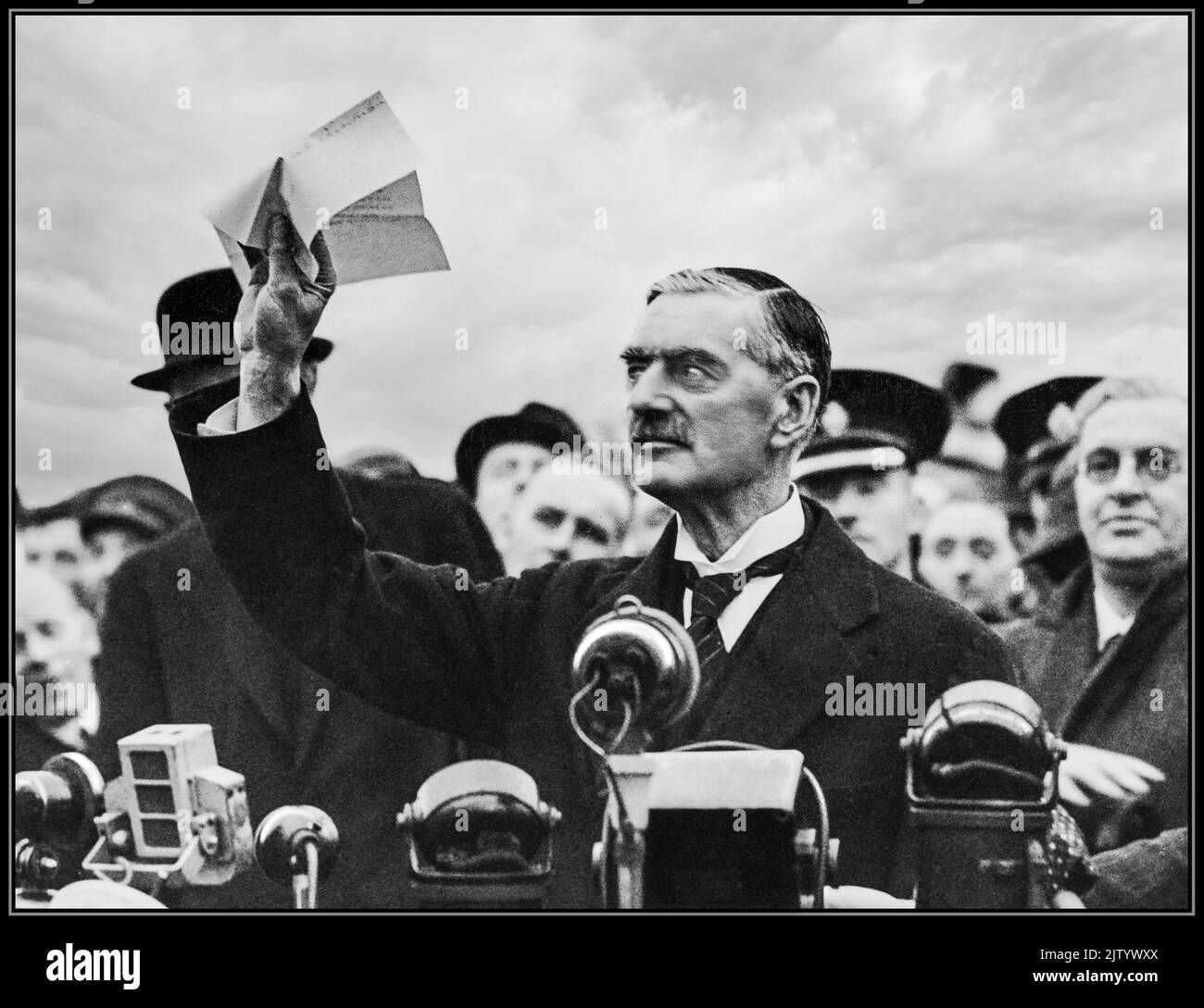Neville Chamberlain 'Peace for our time' 1938 Munich Agreement. Chamberlain holds 'The' piece of paper proudly aloft signed by both Hitler and himself on his return from Munich to Heston Aerodrome in 1938 with the quote; 'a desire never to go to war again...!'   ( JR6T8M alt image) Stock Photo