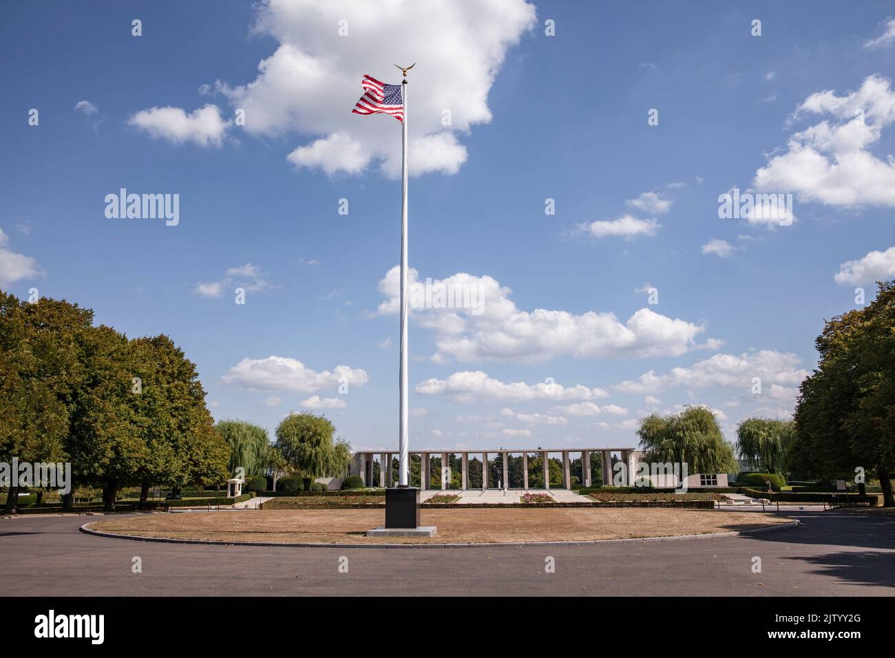 Henri-Chapelle American Cemetery and Memorial, US military cemetery near Welkenraedt, Wallonia, Belgium. Tall pole with Stars and Stripes flag and gol Stock Photo