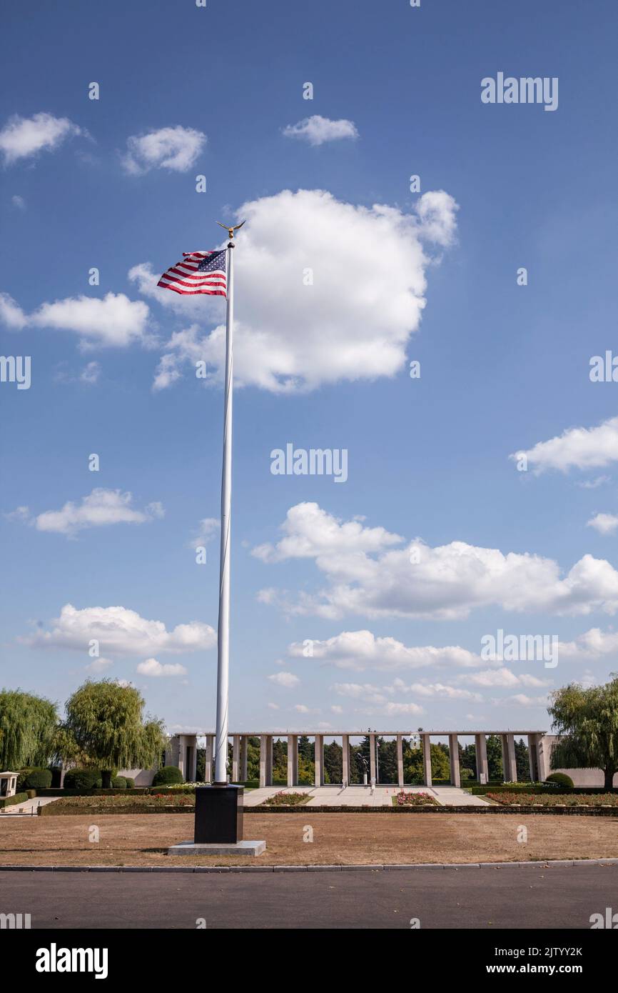 Henri-Chapelle American Cemetery and Memorial, US military cemetery near Welkenraedt, Wallonia, Belgium. Tall pole with Stars and Stripes flag and gol Stock Photo