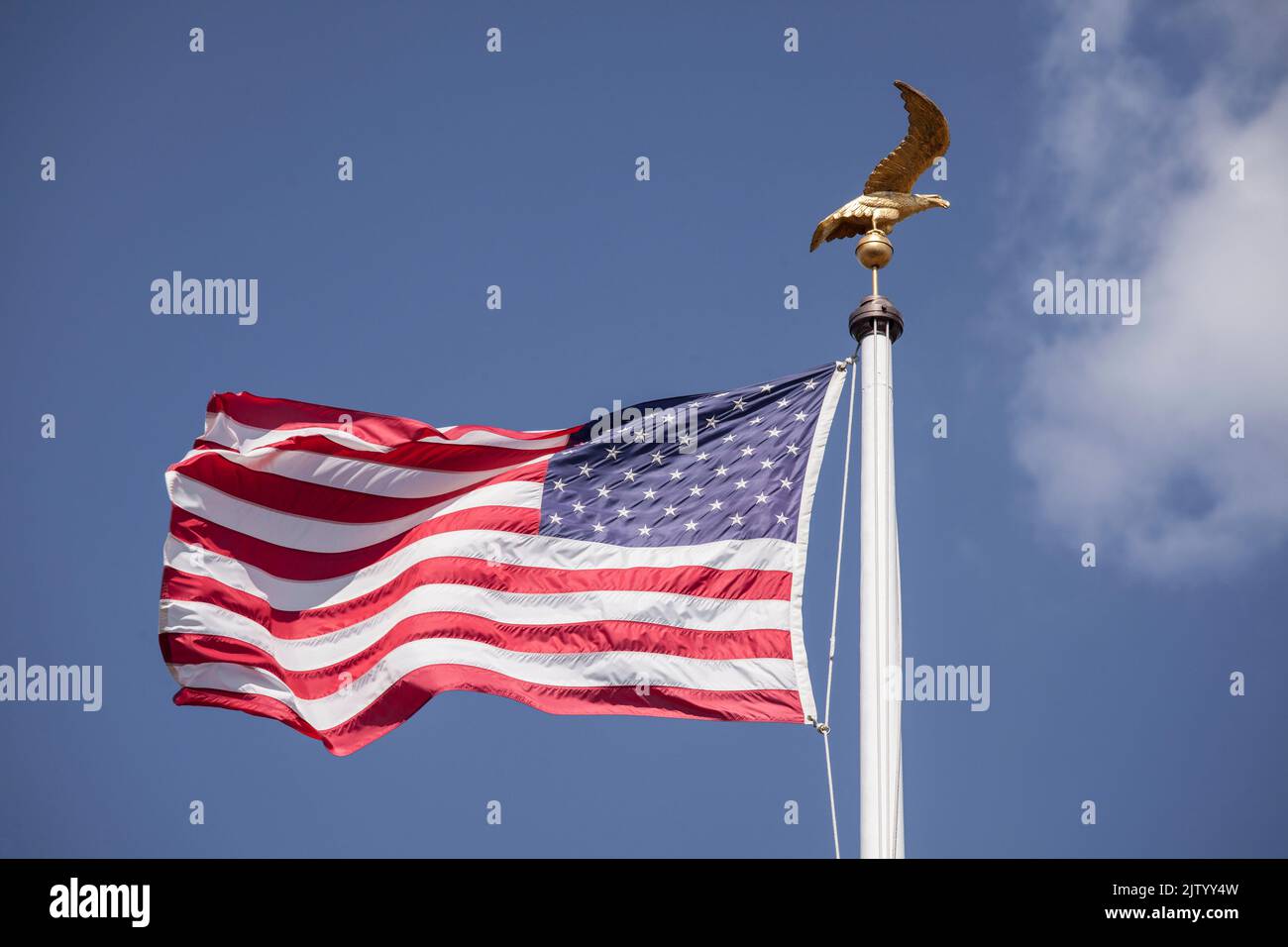 Henri-Chapelle American Cemetery and Memorial, US military cemetery near Welkenraedt, Wallonia, Belgium. Tall pole with Stars and Stripes flag and gol Stock Photo