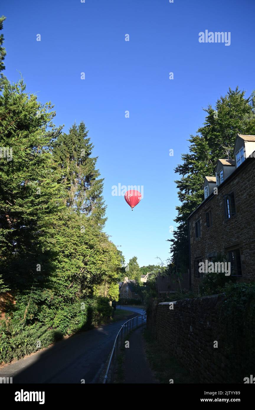 A Cameron A-400 balloon operated by Virgin Days Out flies over the north Oxfordshire village of Hook Norton. Stock Photo
