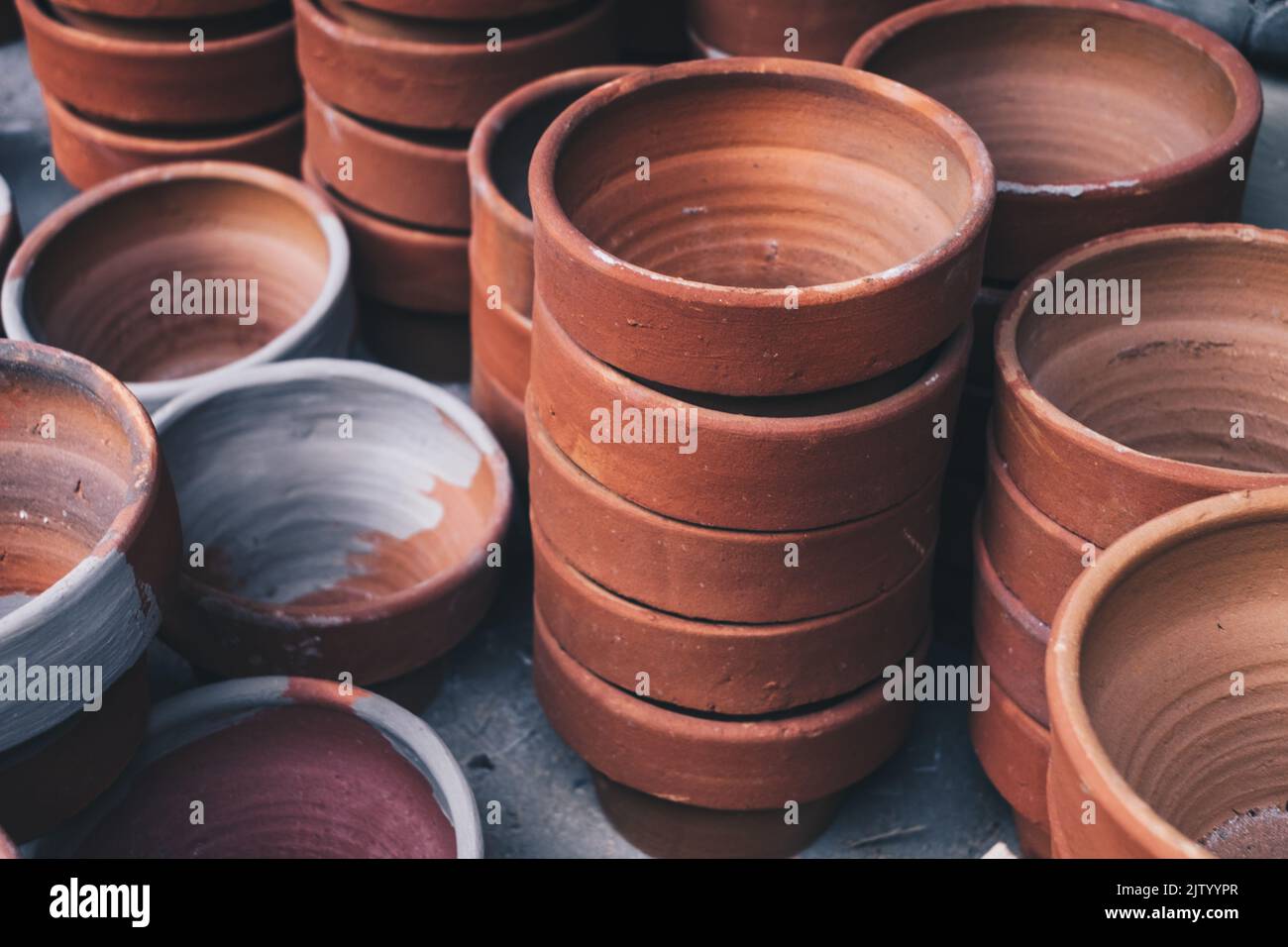 Stacks of newly made unglazed clay flower pot for planting flowers, herbs and vegetables. Selective focus. Stock Photo