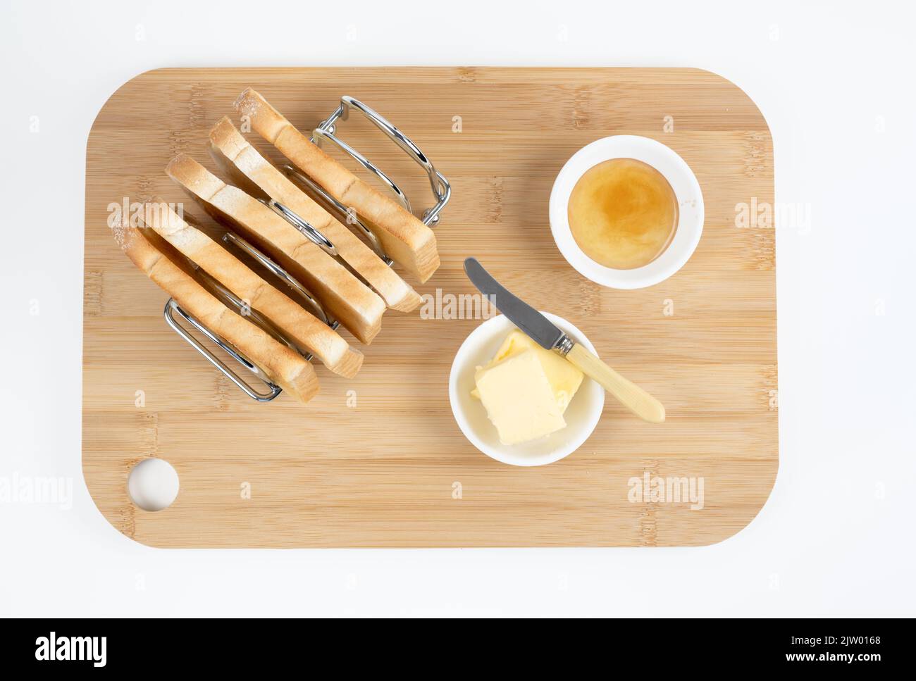 Flat lay toast rack filled with toast butter knife and marmalade on a white background Stock Photo