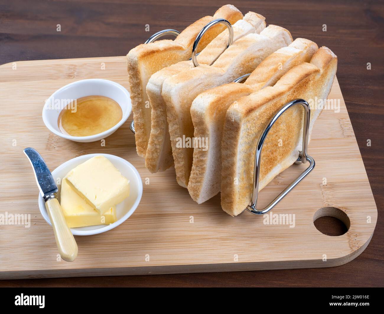 Breakfast toast in rack with butter and marmalade wooden table background Stock Photo