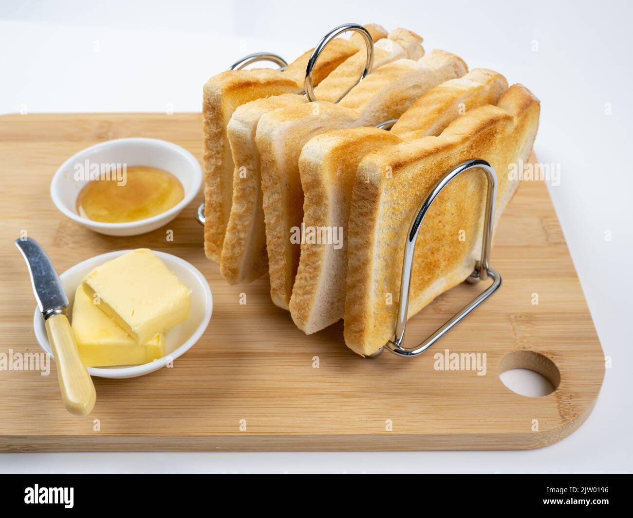 Breakfast toast in rack with butter and marmalade white background Stock Photo