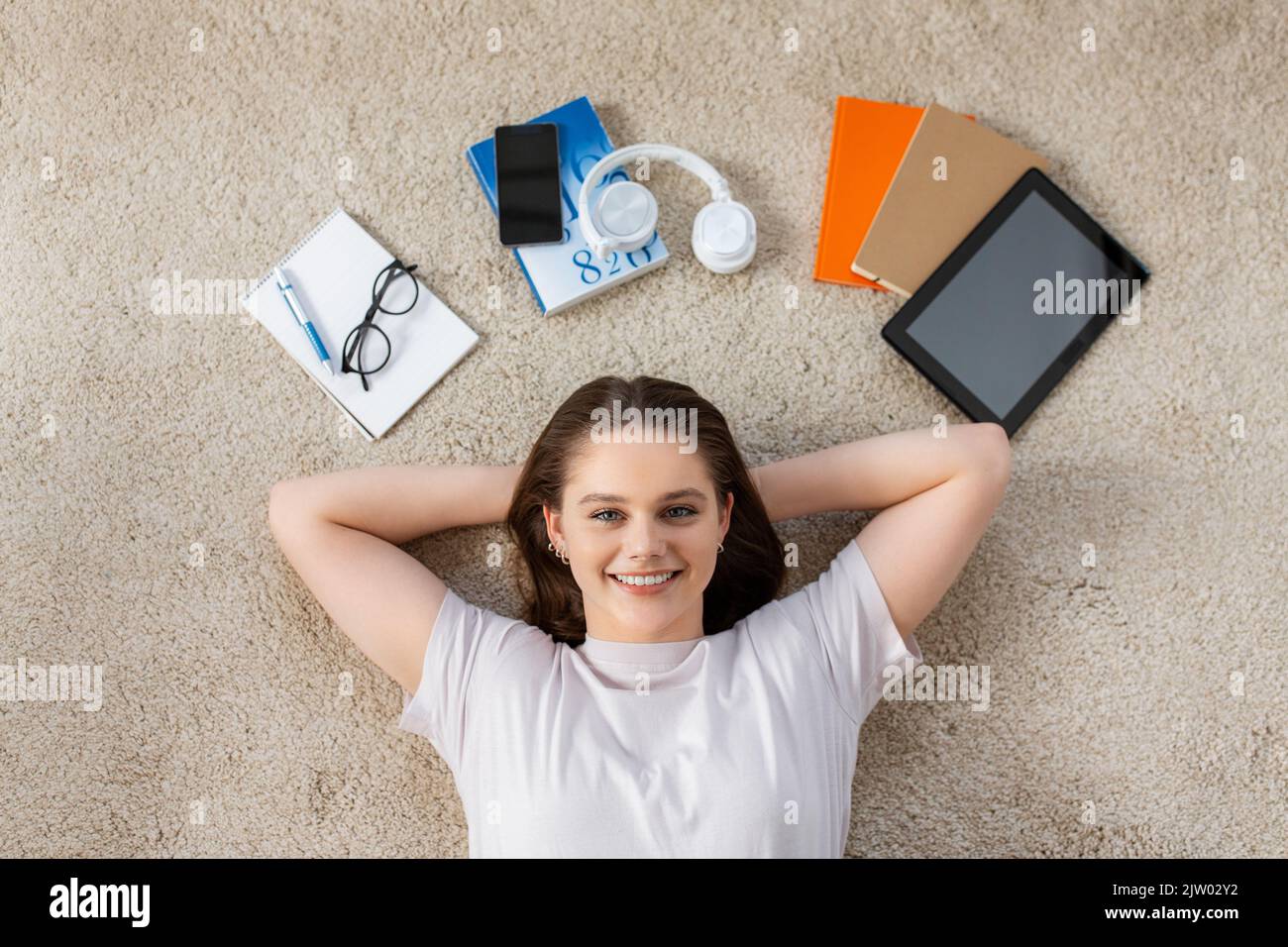 happy student girl with books and gadgets on floor Stock Photo - Alamy