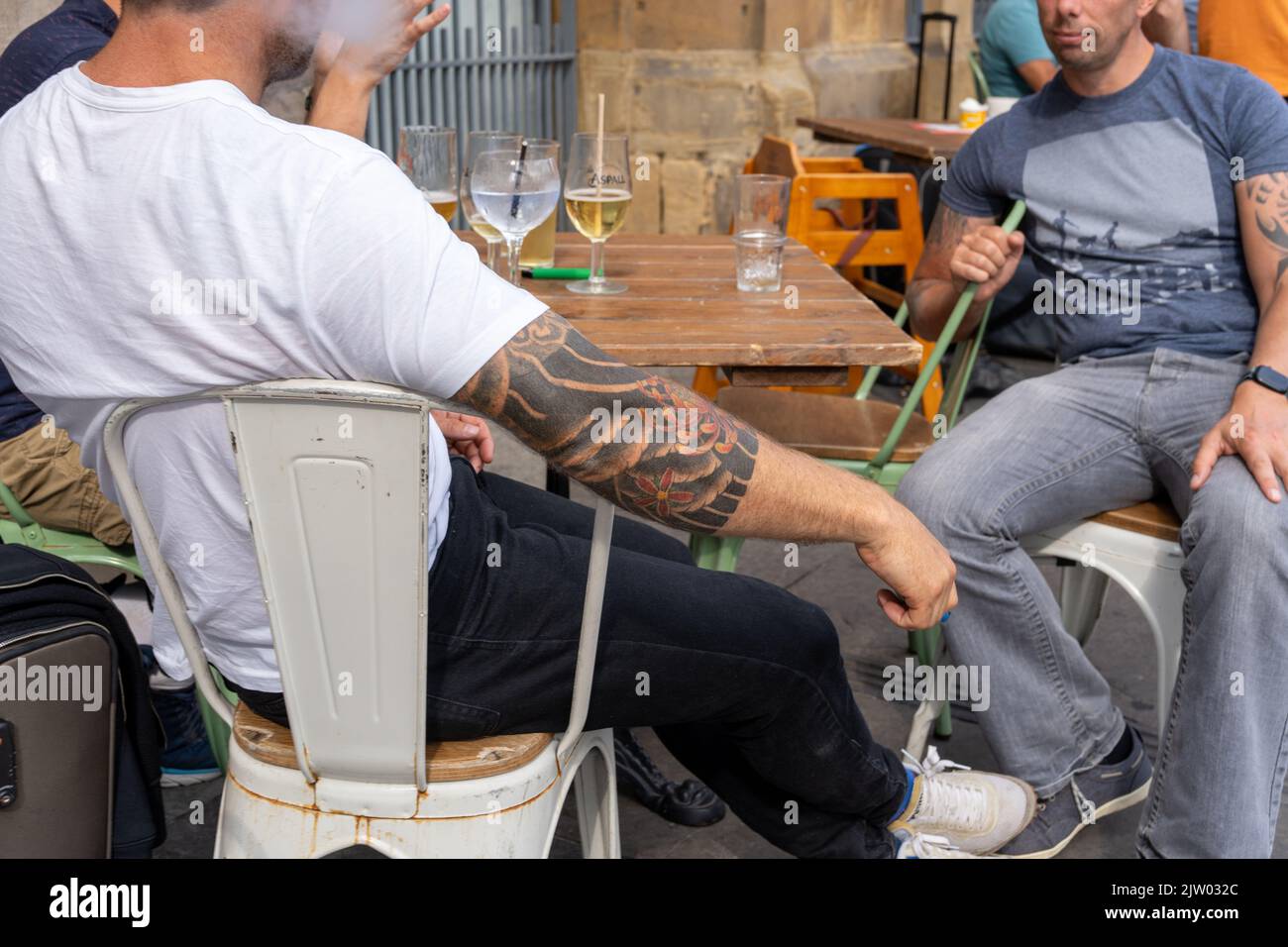 Close up of a group of men drinking on an outdoor bar table at the