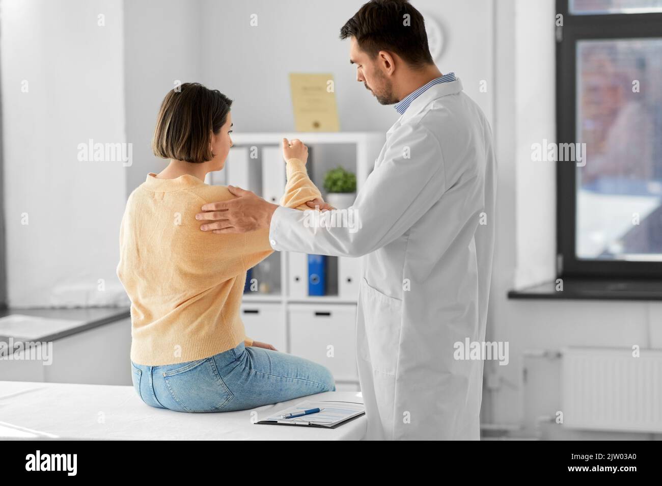 male doctor and woman with sore arm at hospital Stock Photo Alamy