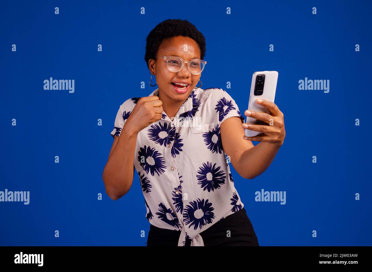 overexcited lady with her phone isolated over blue background Stock ...