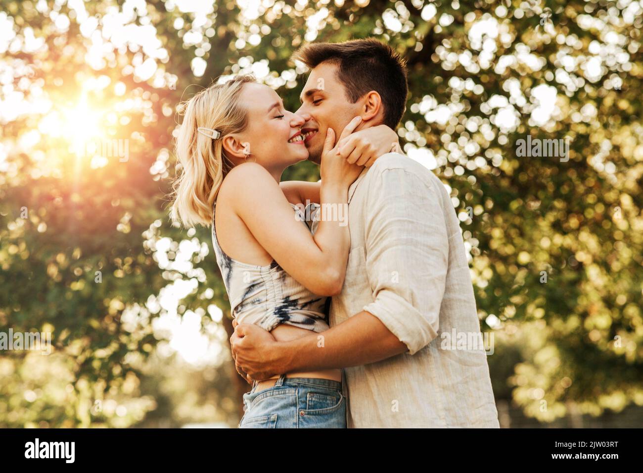 happy young couple kissing and hugging outdoors Stock Photo - Alamy