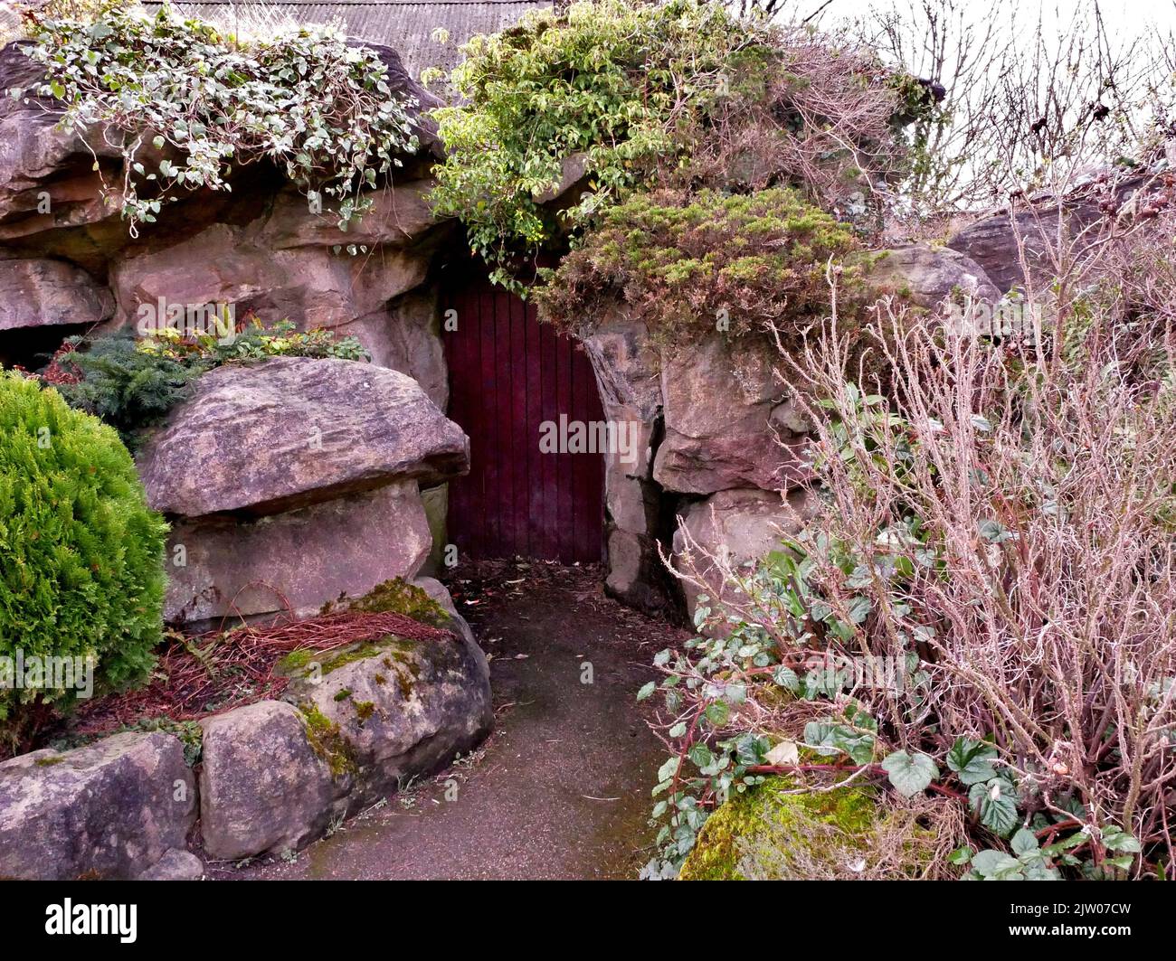 Hidden doorway in rocks with overgrown plants Stock Photo - Alamy