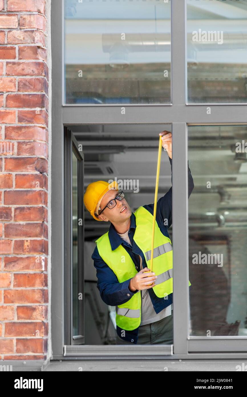 male builder with ruler measuring window Stock Photo - Alamy