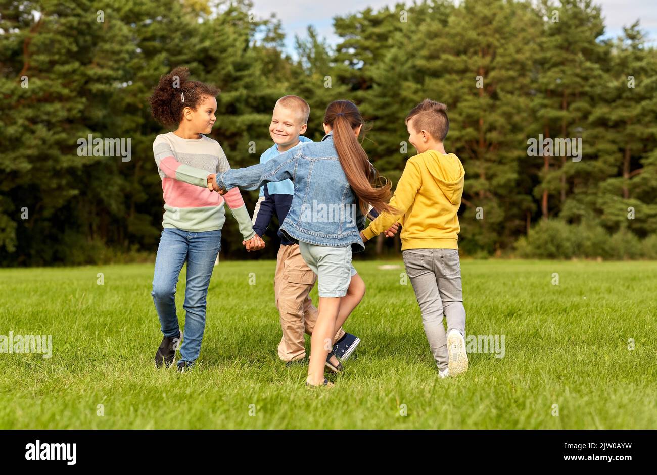 happy children playing round dance at park Stock Photo - Alamy