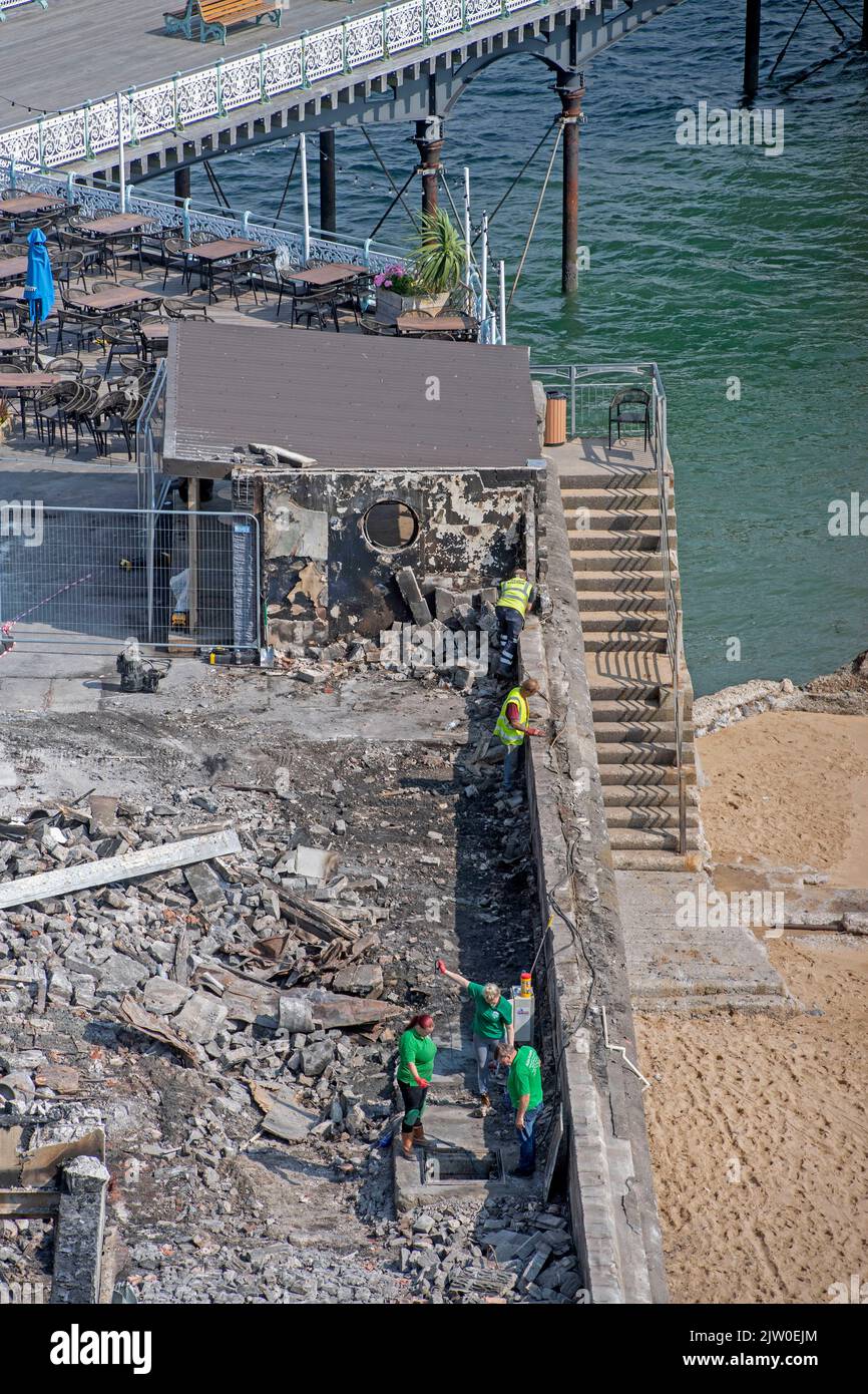 Swansea, UK. 02nd Sep, 2022. Workers clearing up in the remains of the former Cinderella's nightclub today alongside the lighthouse and Pier in the small village of Mumbles, Swansea, UK. The former nightclub was destroyed by a large fire earlier this week Credit: Phil Rees/Alamy Live News Stock Photo