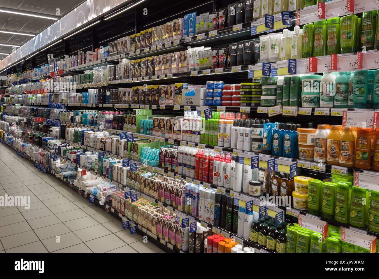 Fossano, Italy - August 11, 2022: Different brands and types of hair conditioner, body creams and cosmetics for sale on the shelf of Italian supermark Stock Photo