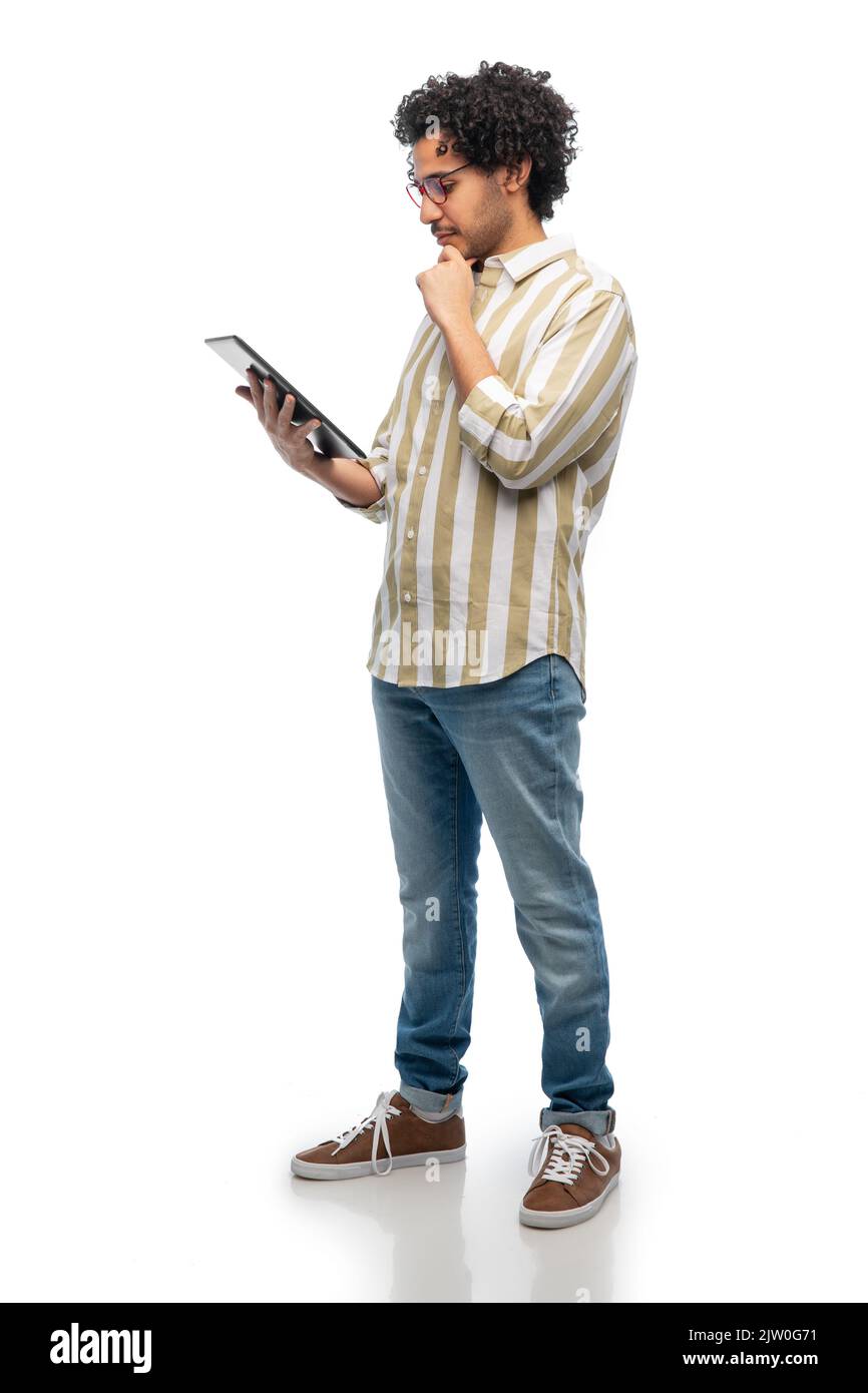 thinking young man in glasses with tablet computer Stock Photo
