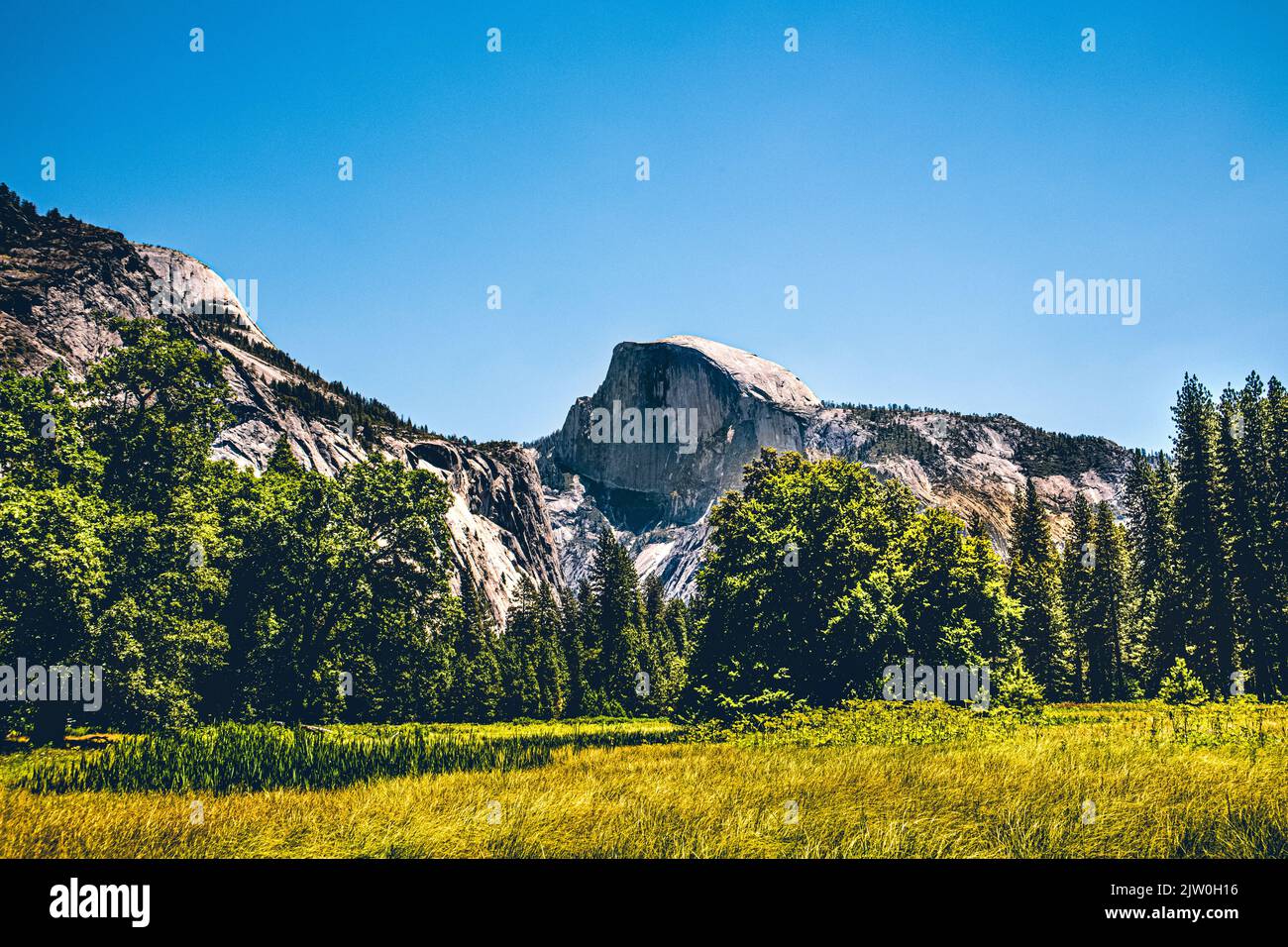 Distant view of the Half Dome inside Yosemite National Park, California. The Half Dome is a beautiful and popular landmark inside the national park. Stock Photo