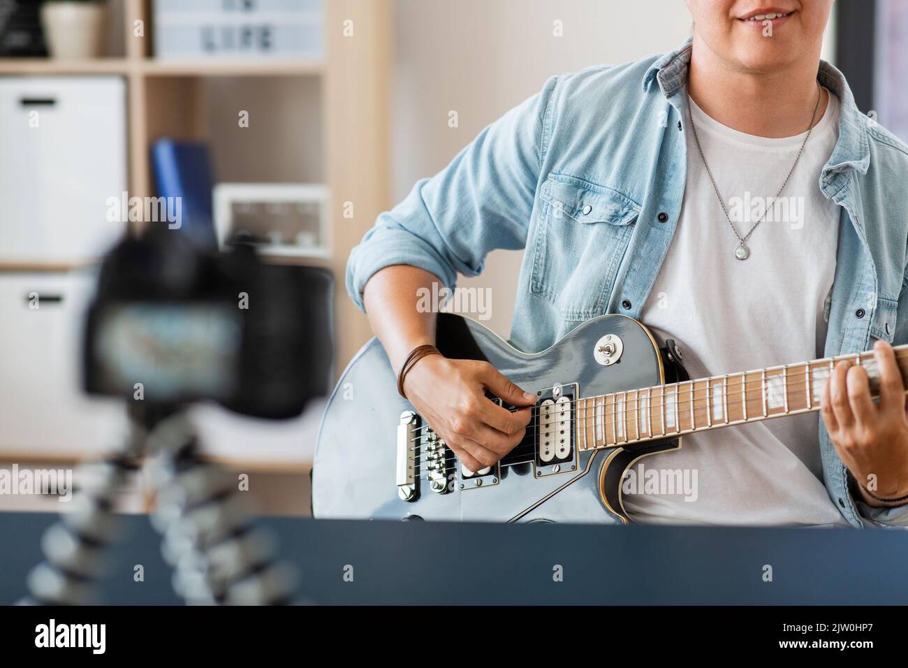man with camera playing guitar and recording video Stock Photo Alamy