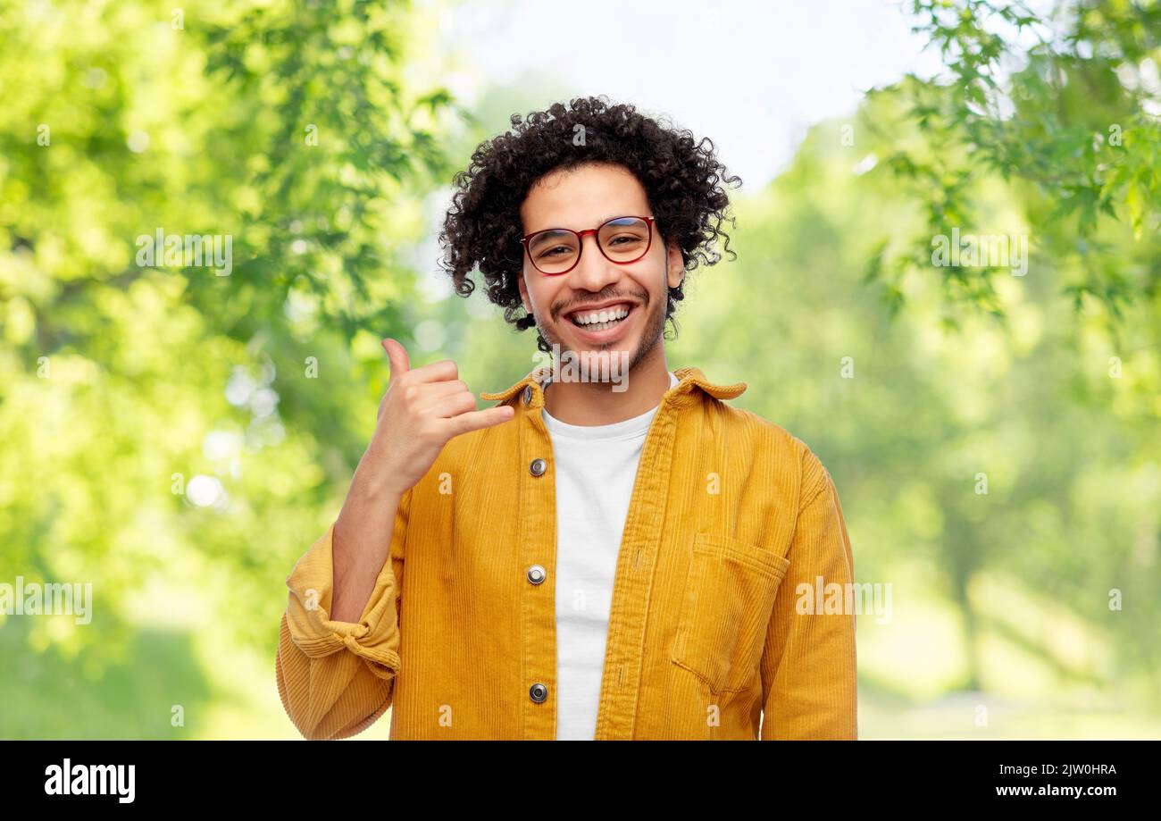 man making phone gesture on natural background Stock Photo