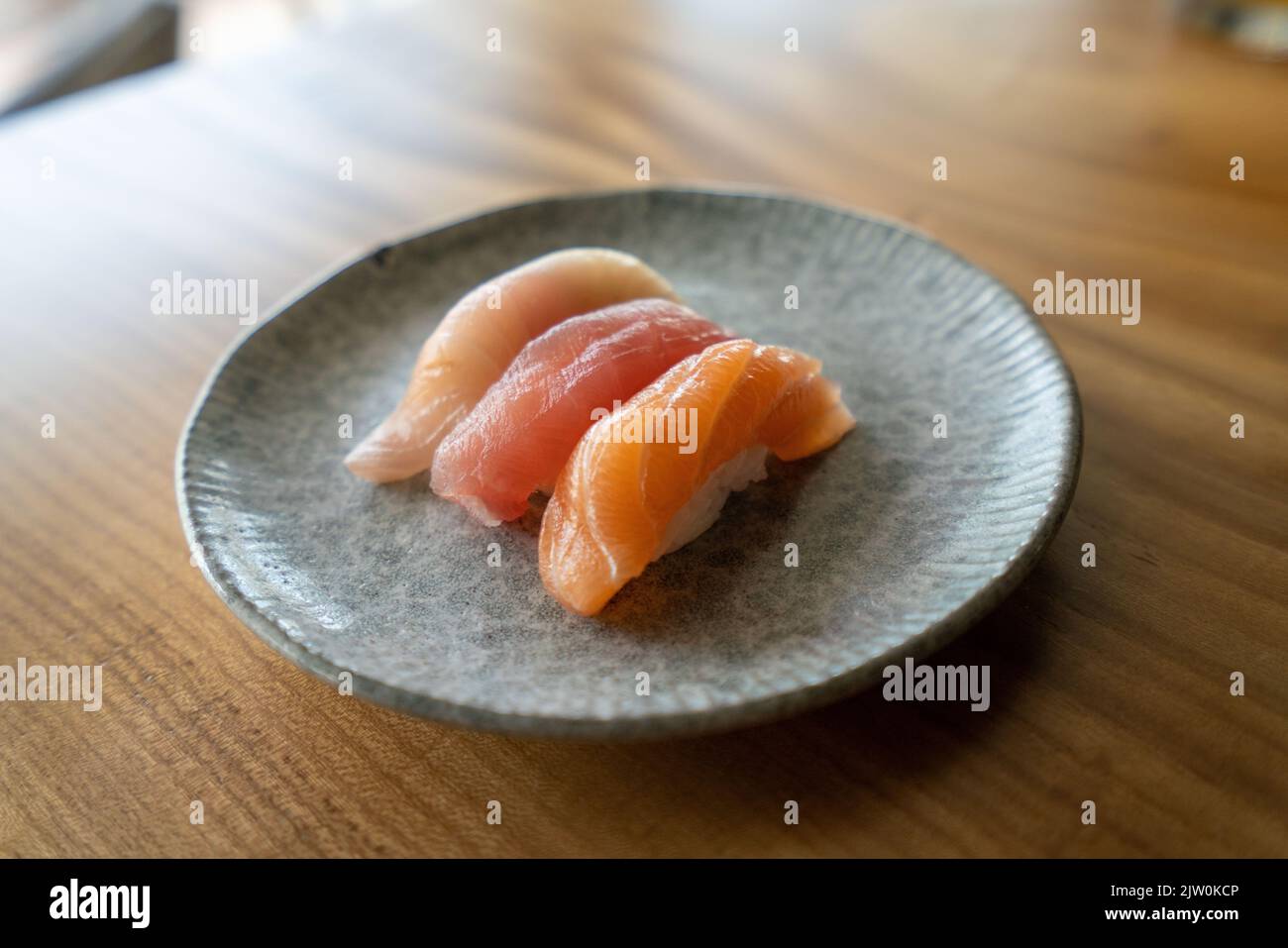 A closeup shot of salmon, tuna, and yellowtail pieces of sushi at a