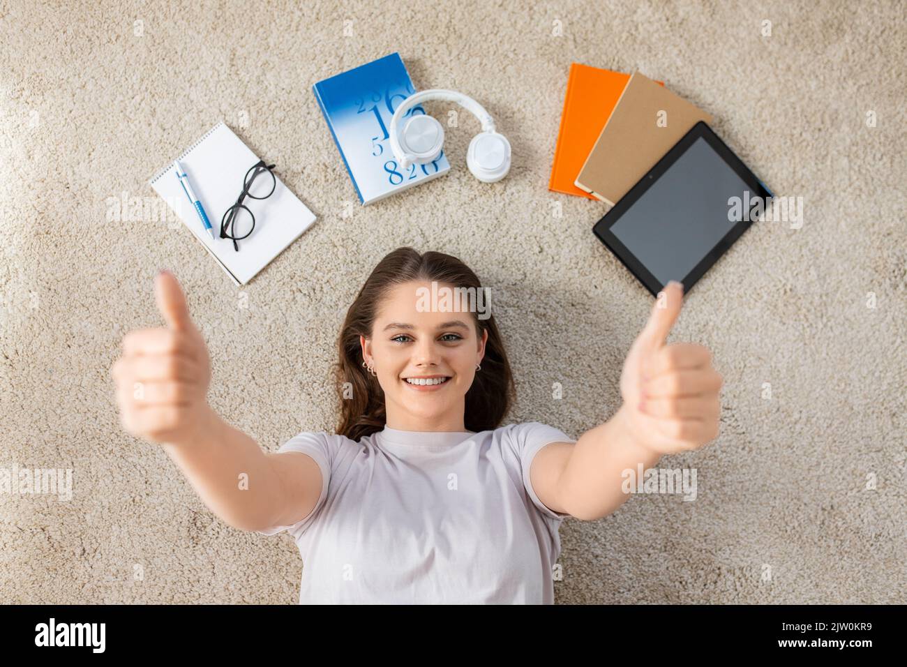 happy student girl with books and gadgets on floor Stock Photo - Alamy