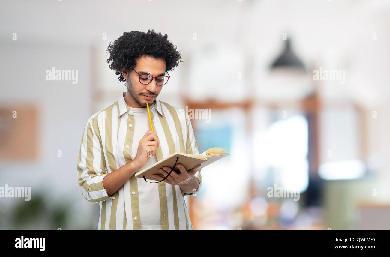 thinking young man with diary and pencil at office Stock Photo