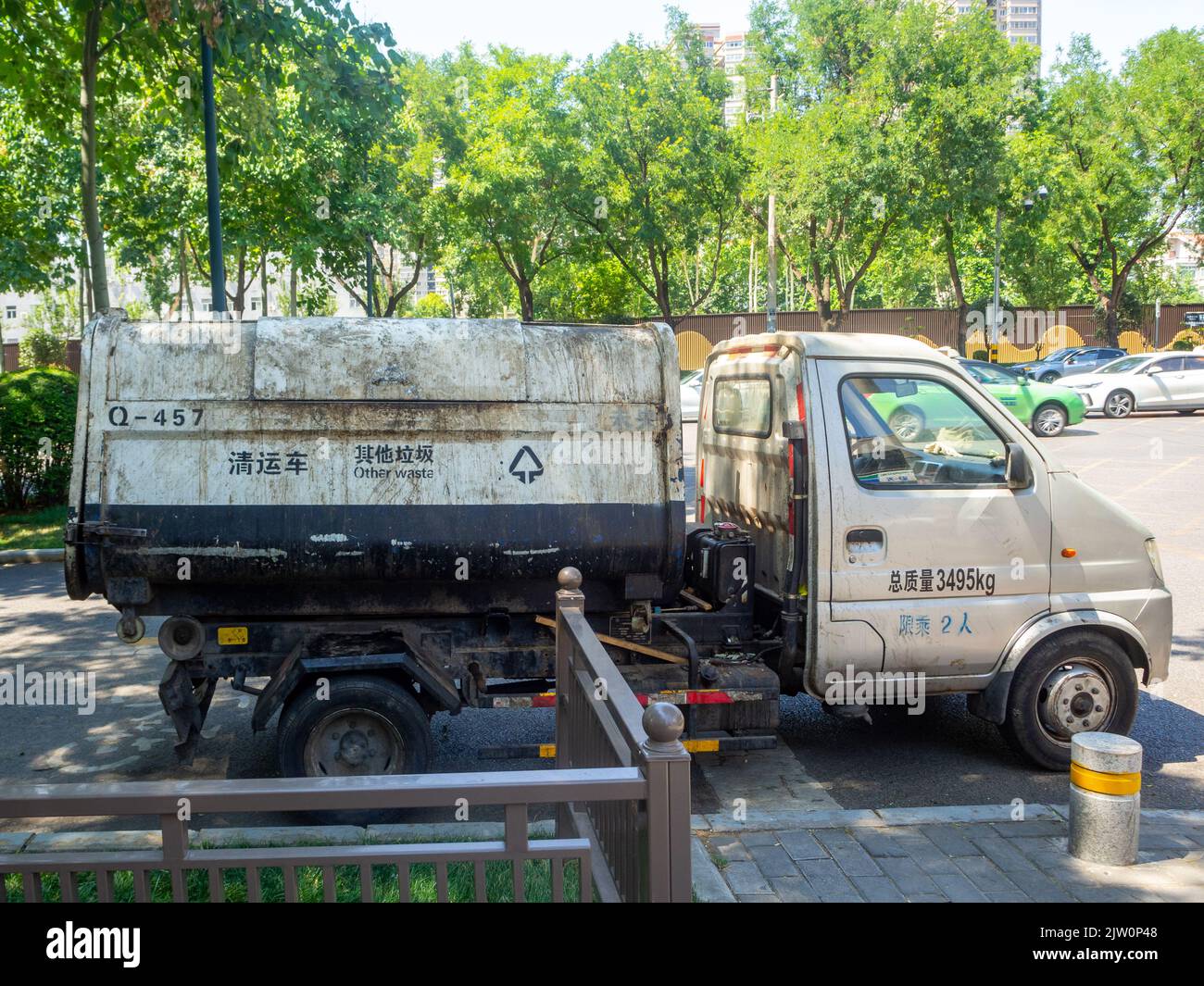 Side view of a garbage truck parked in a city street. Stock Photo
