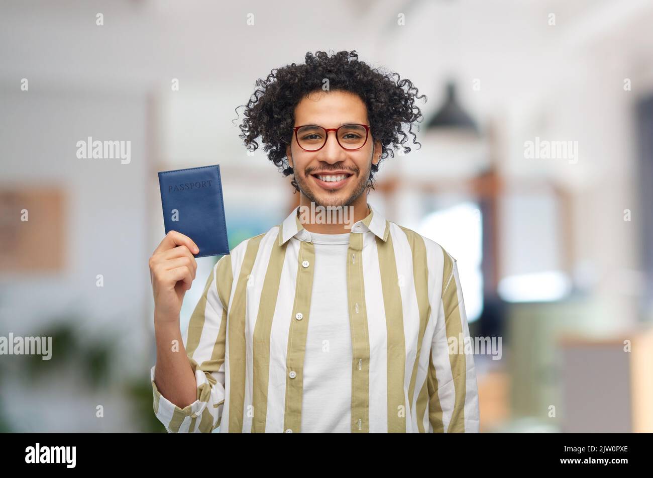 smiling man with passport at office Stock Photo
