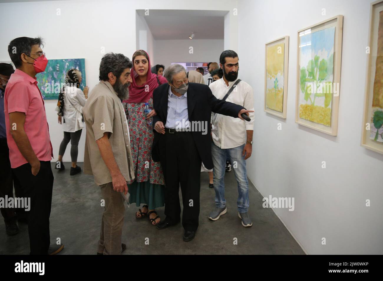 Tehran, Iranan. 2nd Sep, 2022. Iranian poet, novelist, screenwriter, and painter, AHMADREZA AHMADI (C) (born 1940) attends his second painting solo exhibition titled ''There Was a Stain of Life on the Wall'' at O Gallery, in Tehran, Iran. Ahmadi's first book of poetry, Tarh (Sketch), was published in 1962. His poetry has its roots in French Surrealism and the American Imagists especially in poets like Saint John Perse, Paul Eluard, Louis Aragon, and Ezra Pound. The history of Persian modern poetry calls him the founder of New Wave Poetry in Iran. Stock Photo