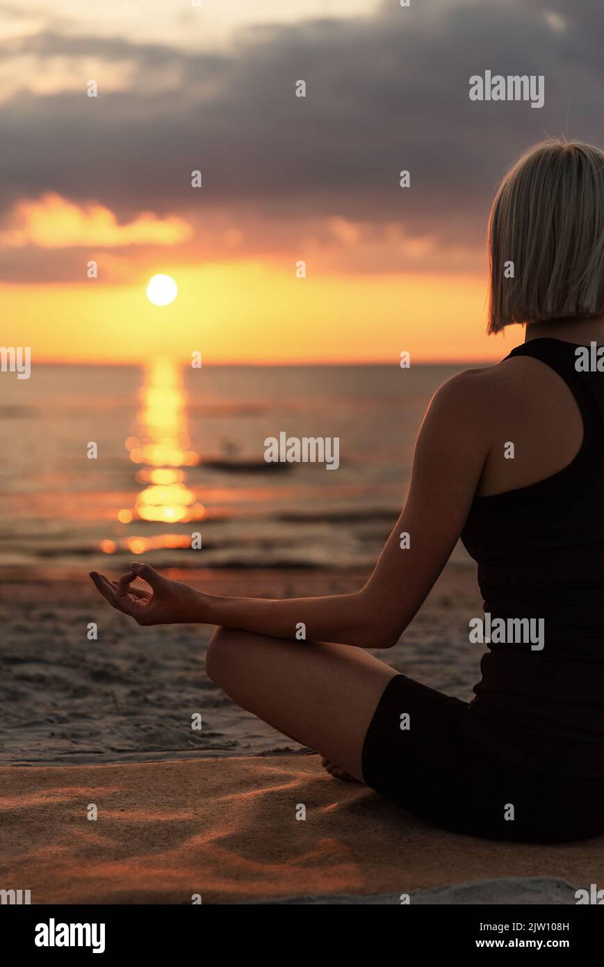 woman meditating in lotus pose on beach Stock Photo - Alamy