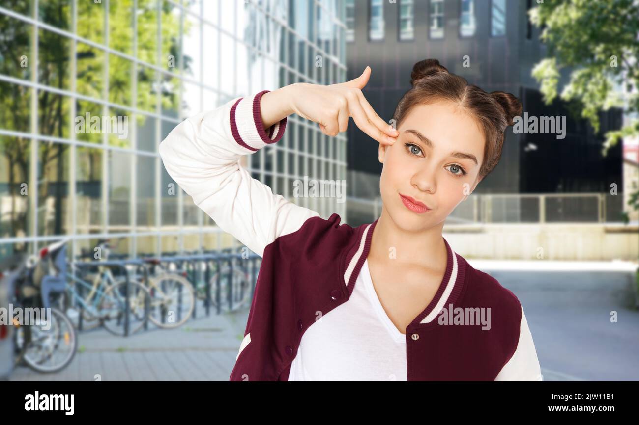 teenage girl making finger gun gesture in city Stock Photo