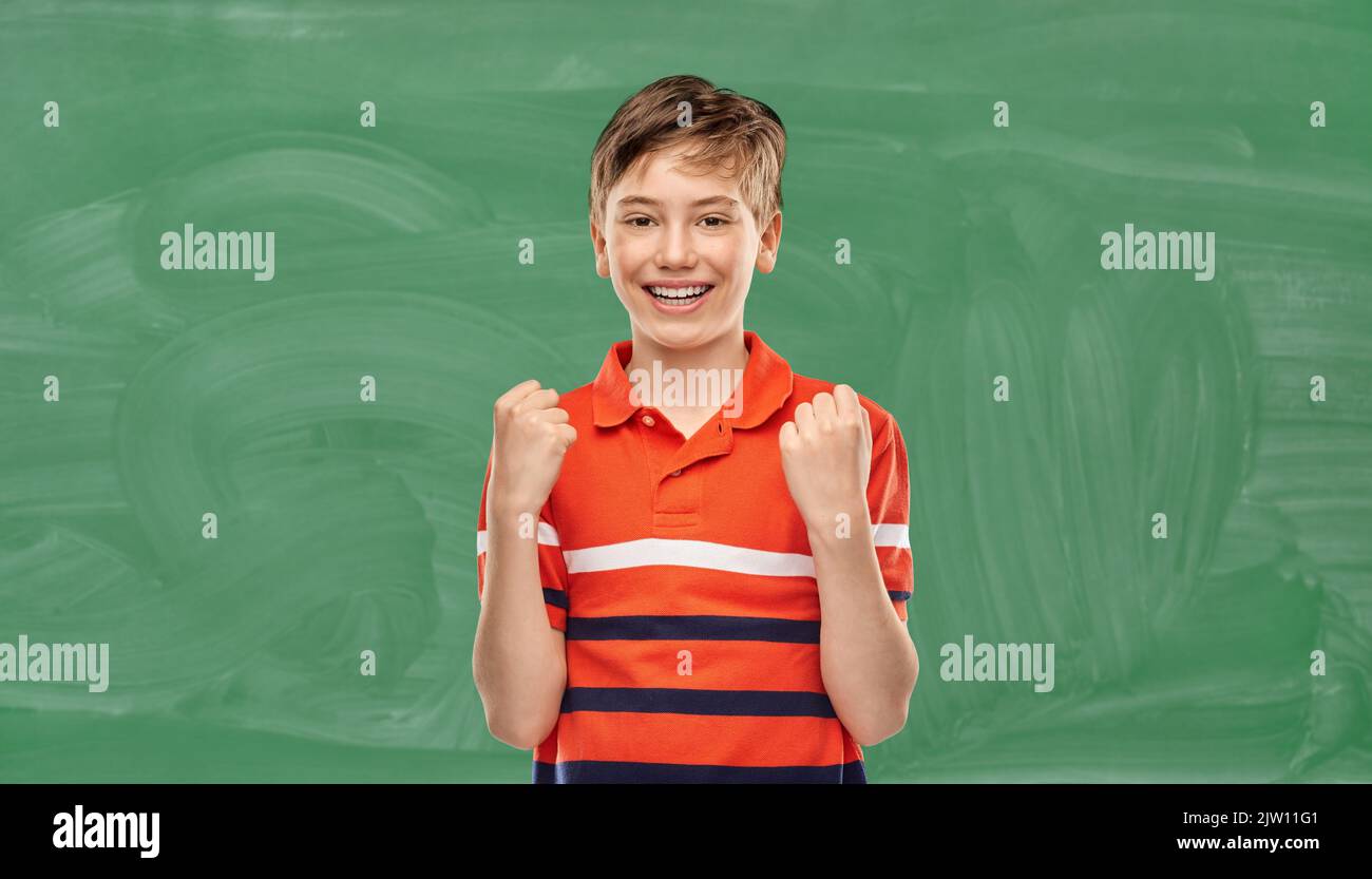 student boy celebrating success over chalkboard Stock Photo