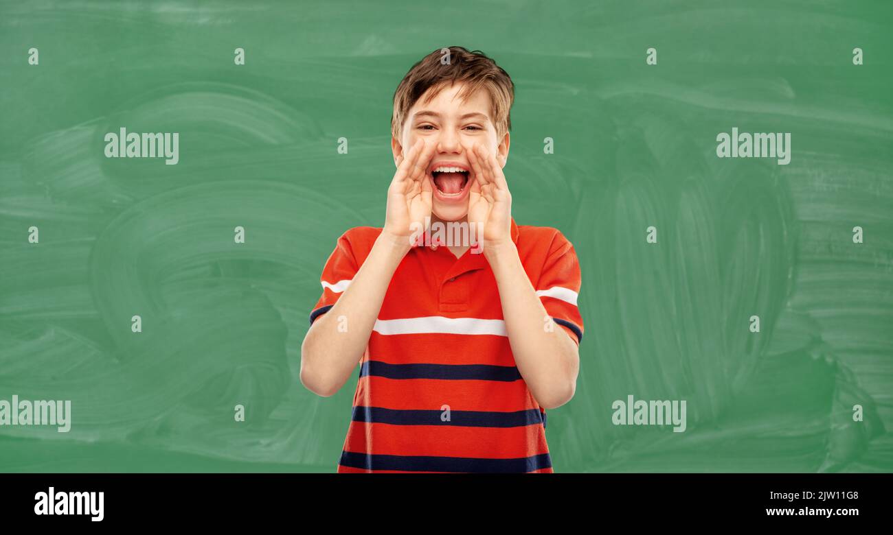 student boy shouting over green chalkboard Stock Photo