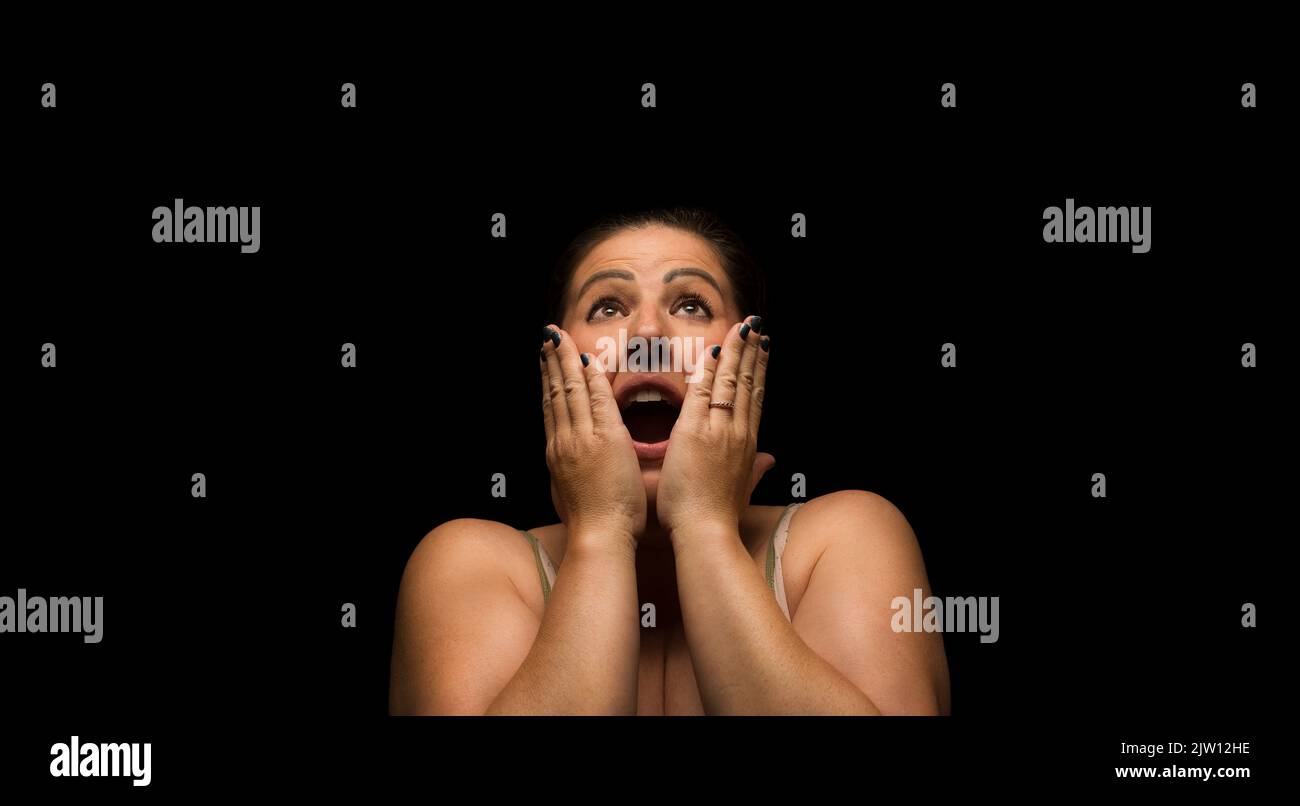 Caucasian female woman with a shocked expression looking upwards. Stock Photo