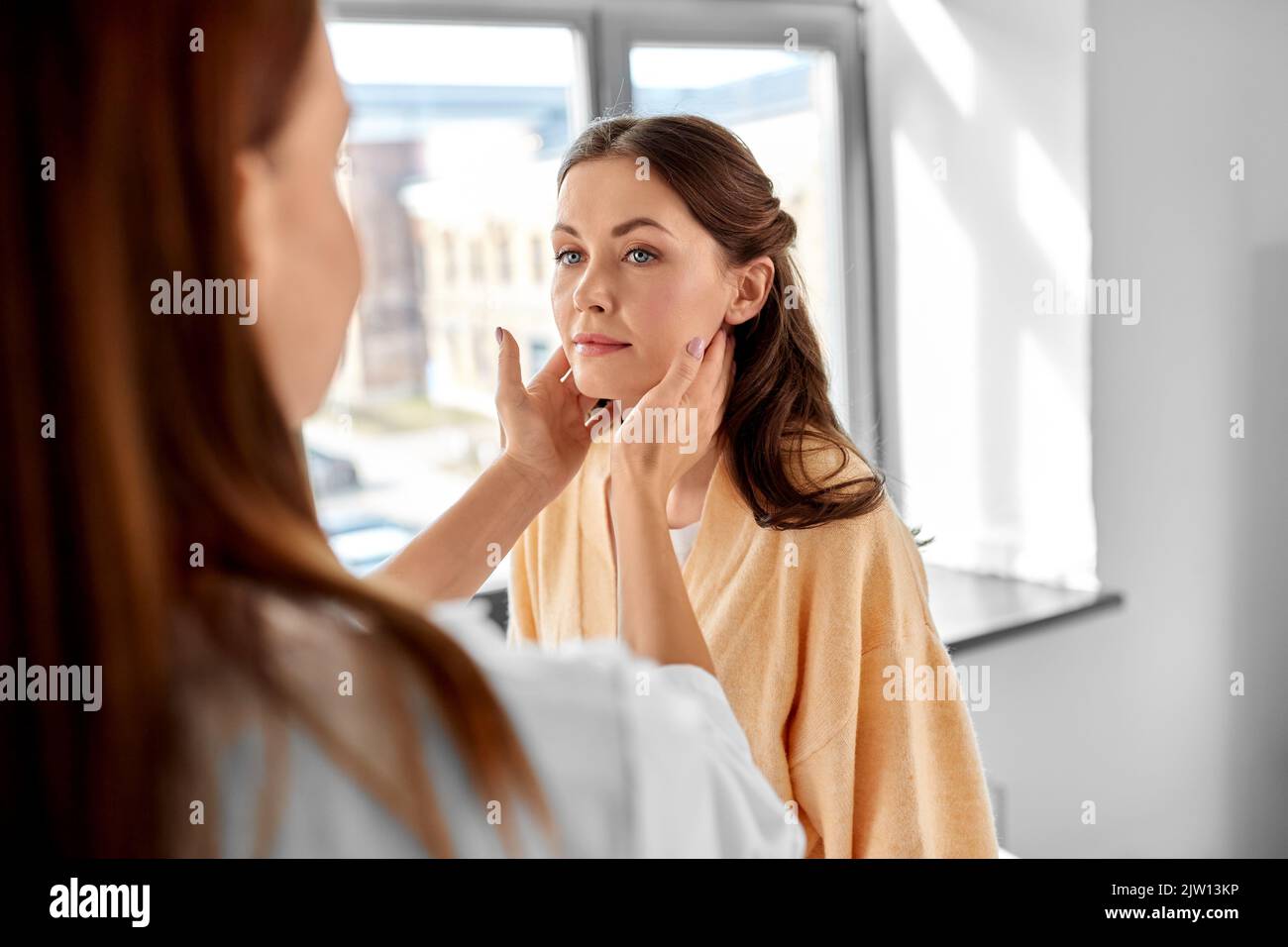 doctor checking lymph nodes of woman at hospital Stock Photo