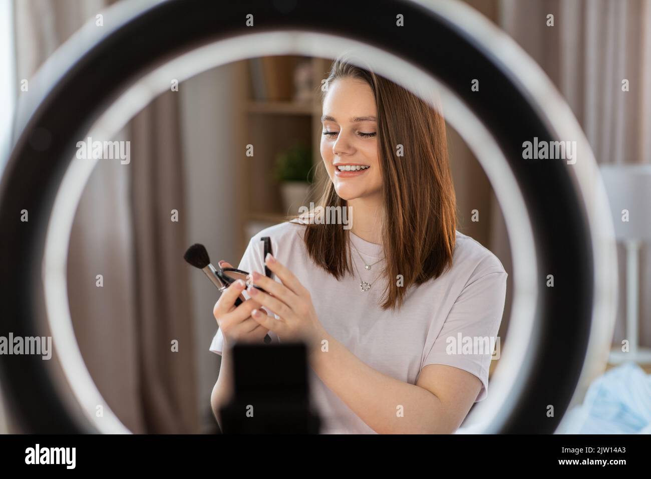 girl blogger with ring light applying make up Stock Photo