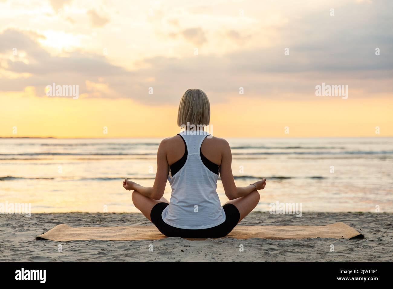 woman meditating in lotus pose on beach Stock Photo - Alamy