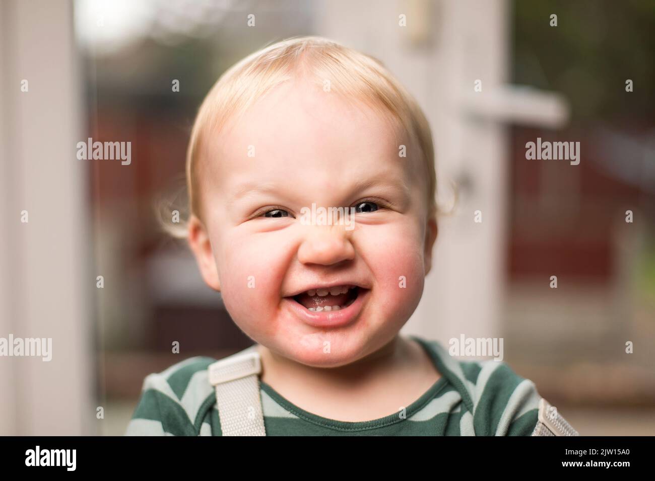 Close up of young toddler as he looks into the camera and fully a funny looking face. Stock Photo