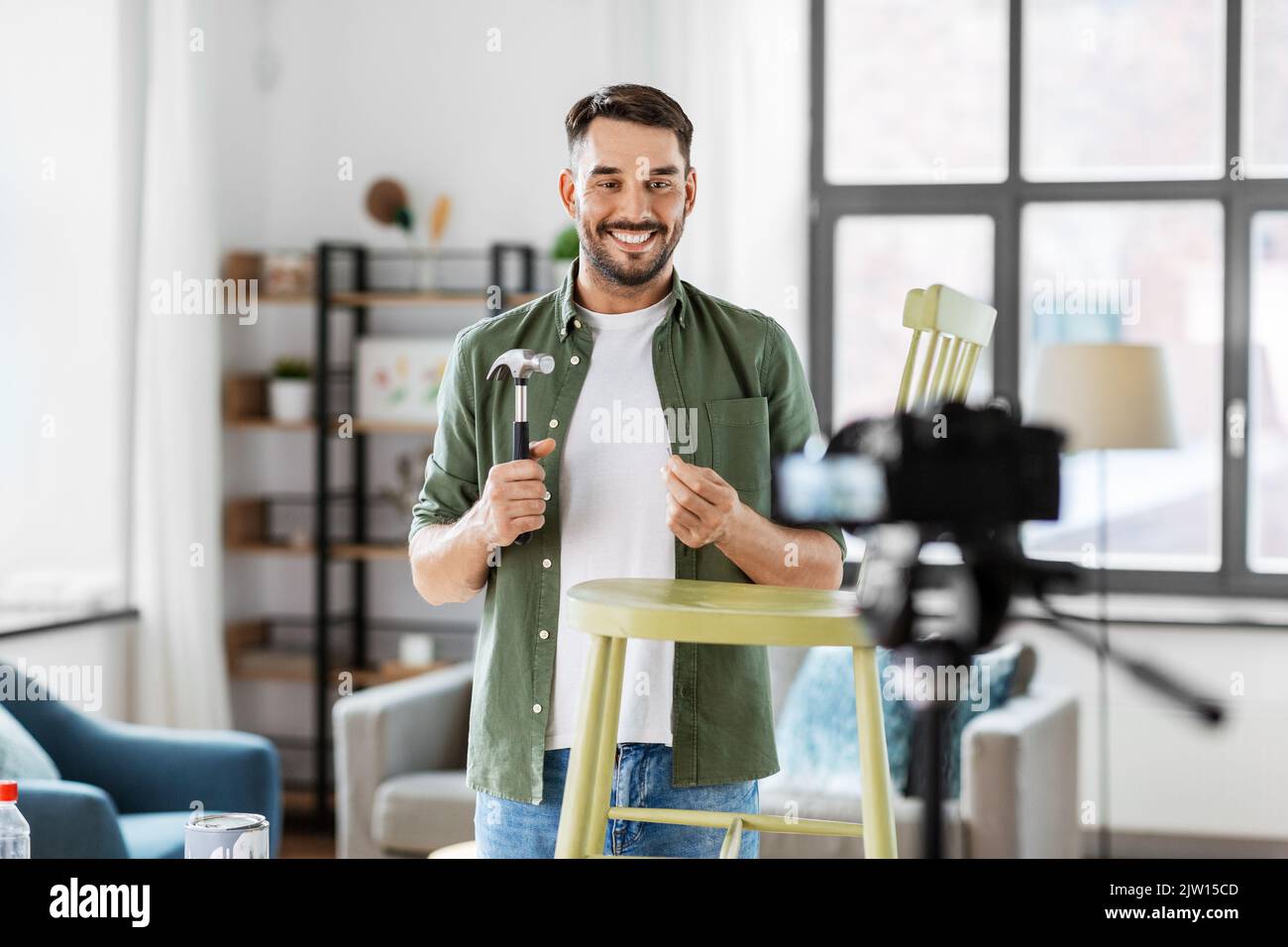 male blogger with hammer showing chair renovation Stock Photo - Alamy