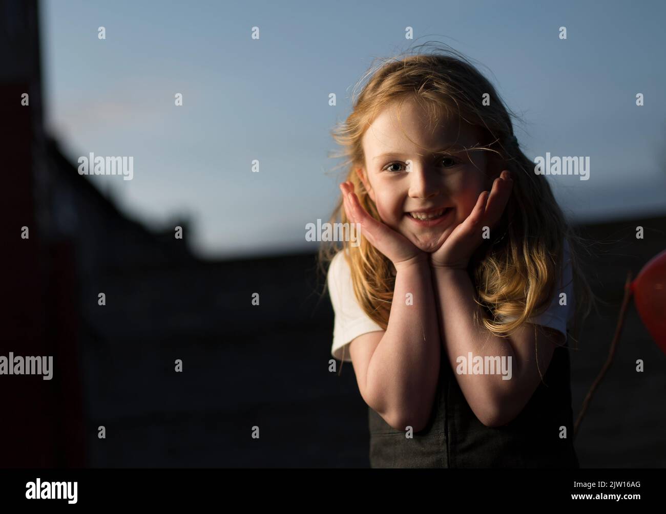 Caucasian young girl poses with hands outside in school uniform. Stock Photo