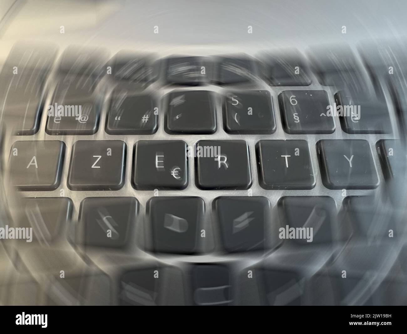 Radial blurred close-up view on an a grey Azerty keyboard letters in the office Stock Photo