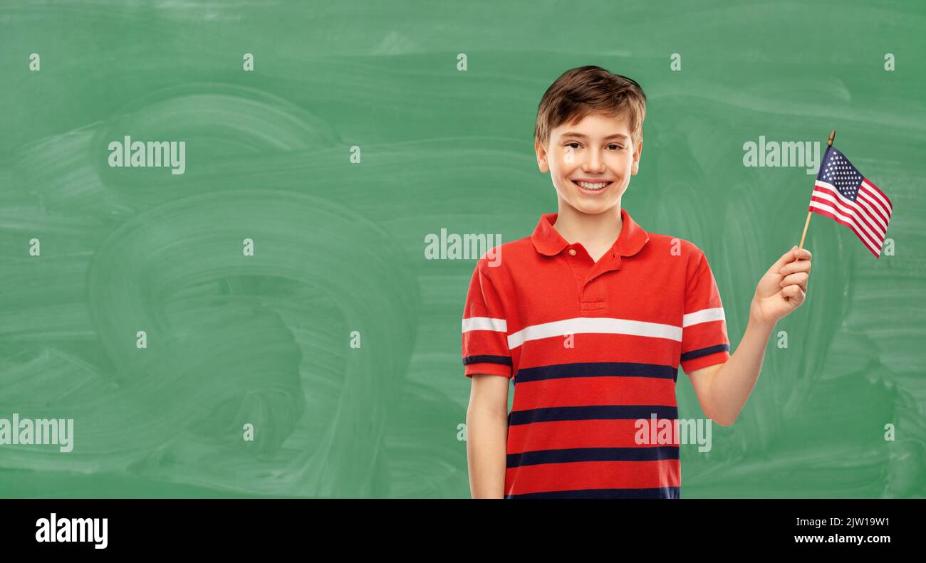 smiling boy with flag of america over chalkboard Stock Photo