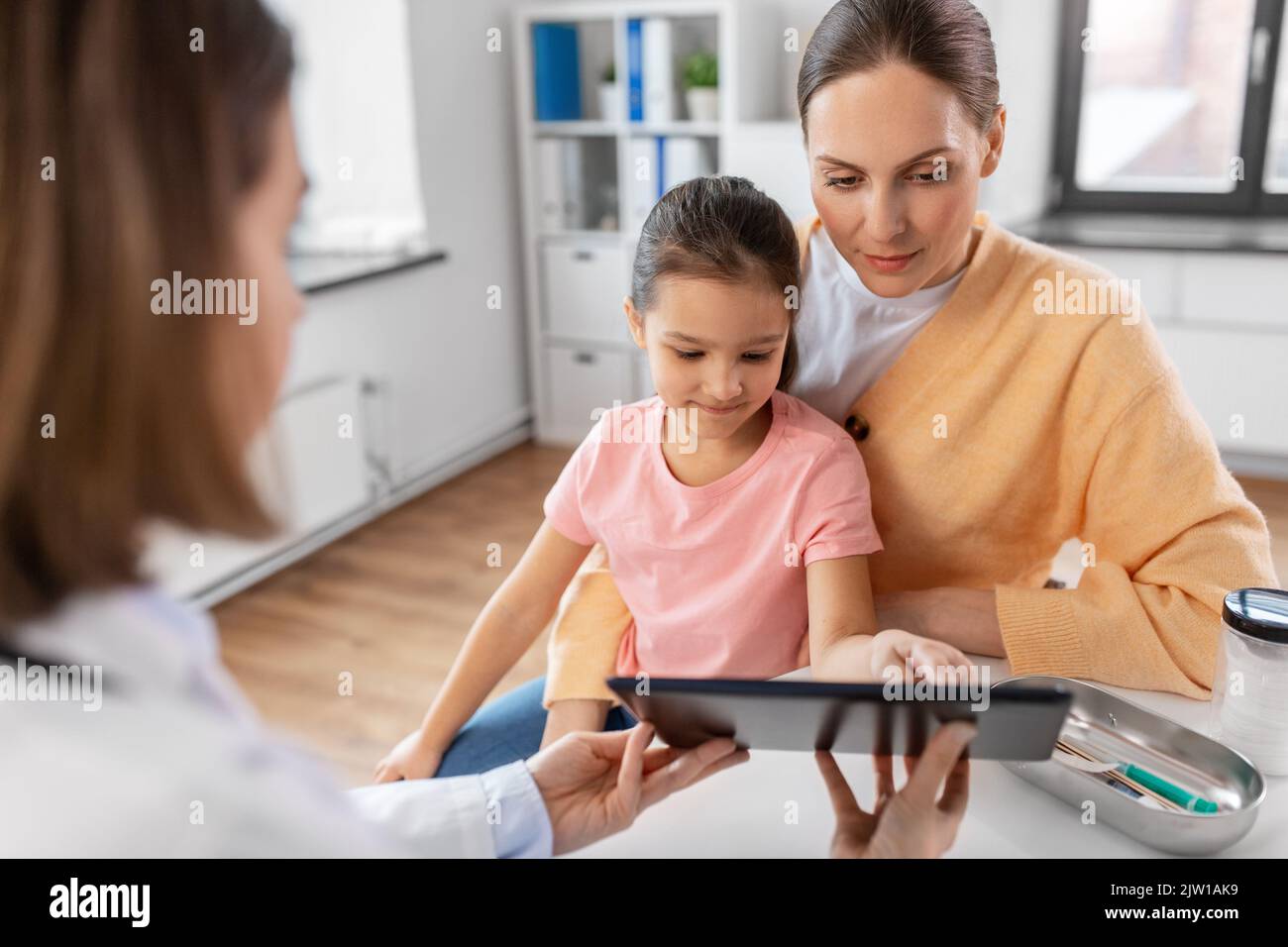 mother, child and doctor with tablet pc at clinic Stock Photo - Alamy