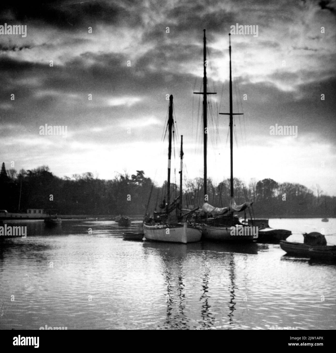 AJAXNETPHOTO. 1950. HAMBLE RIVER, SWANWICK, SOUTHAMPTON, ENGLAND. - ARCHER YACHT - JOHNNY JOHNSON'S FAMOUS COLIN ARCHER DESIGNED CRUISING YACHT ESCAPE (CENTRE, LEFT.) BUILT AT RISOR NORWAY IN 1937 AT HER RIVER MOORING OPPOSITE A.H. MOODY YARD UNDER A WINTRY SKY.PHOTO:©SUSANNAH RITCHIE COLLECTION/AJAX REF:SR 1950 Stock Photo