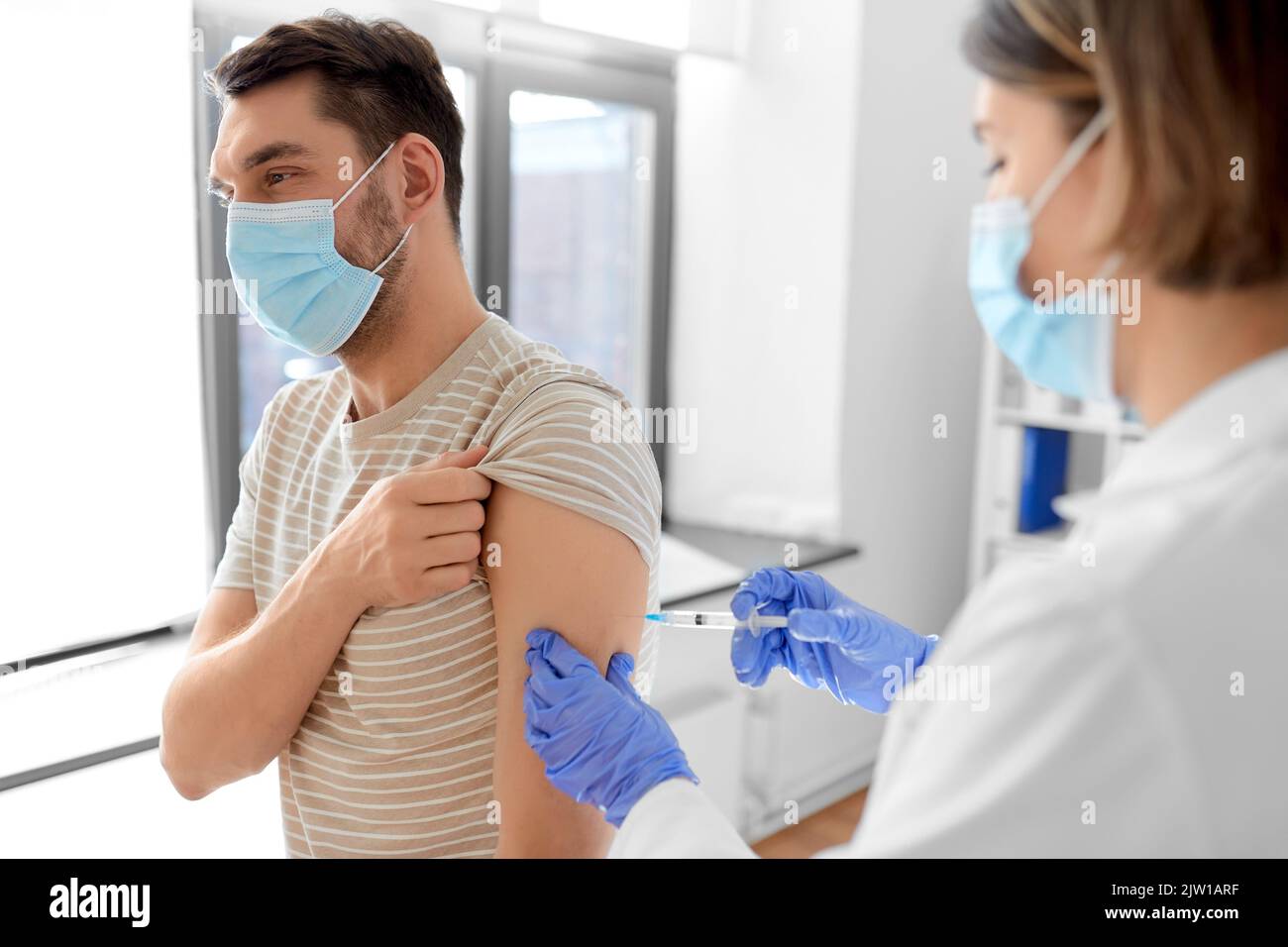 doctor with syringe vaccinating male patient Stock Photo - Alamy