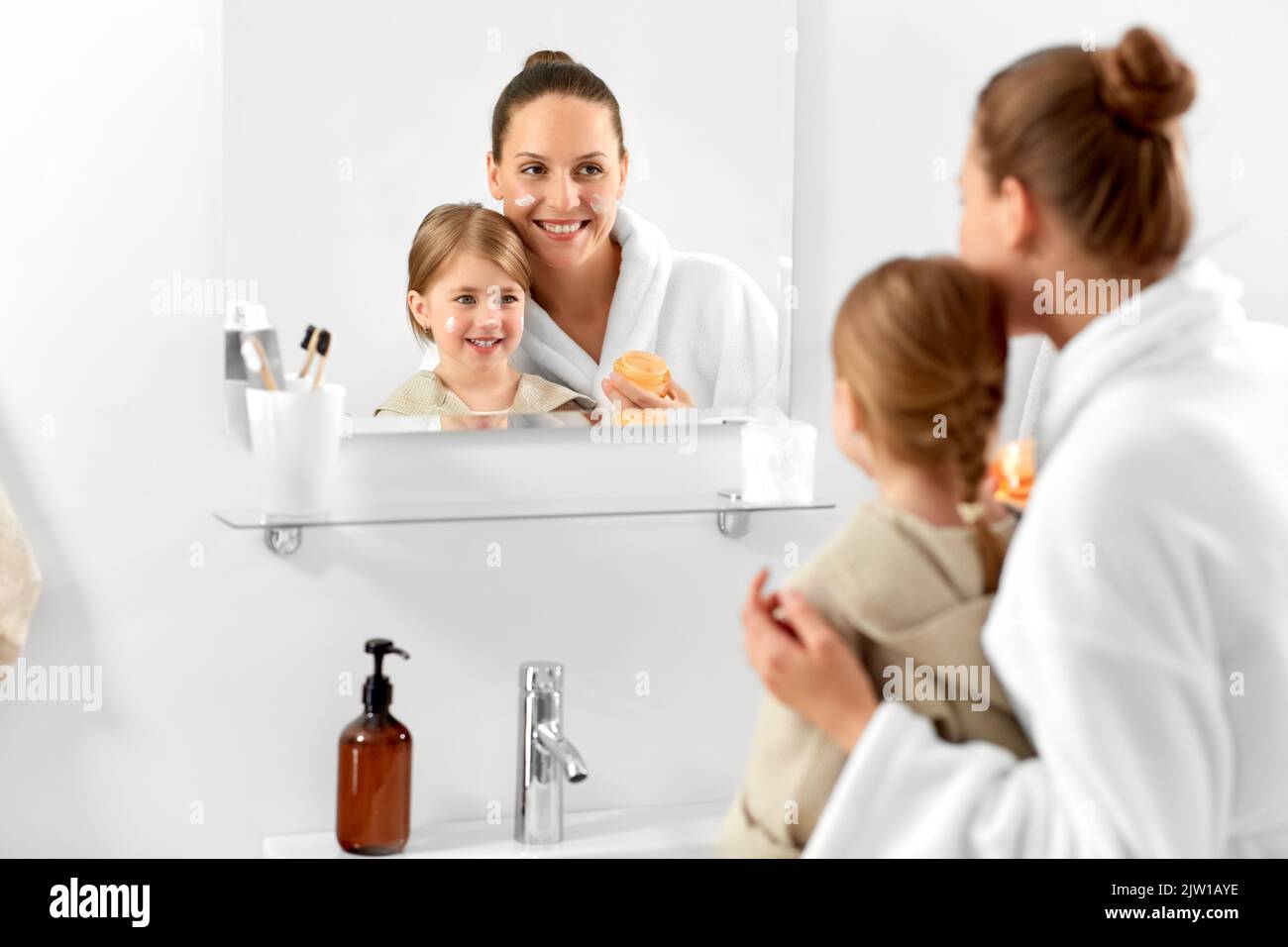 mother and daughter with moisturizer in bathroom Stock Photo Alamy